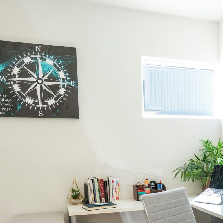 Bright coaching office with a desk, computer and framed art