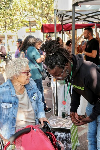 Volunteer helping an older woman at an outdoor community event